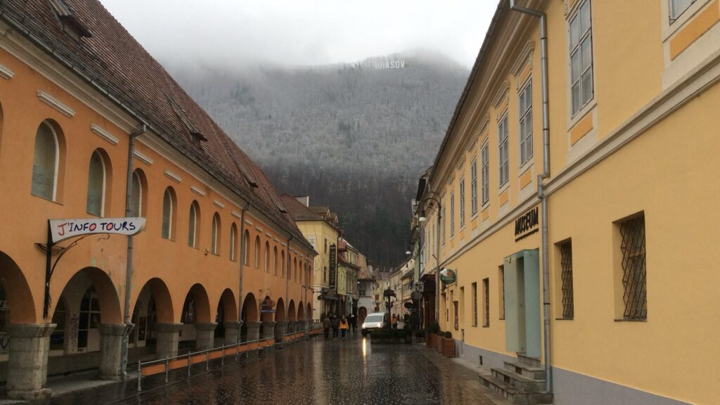 Narrow street in Brașov with the Brașov sign on Mount Tâmpa